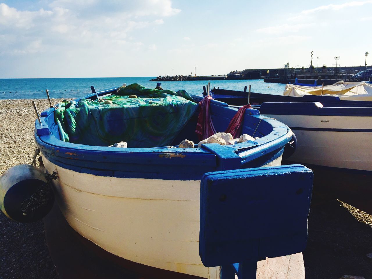 nautical vessel, sea, transportation, mode of transport, moored, boat, water, sky, beach, abandoned, horizon over water, shore, harbor, tranquility, rope, day, cloud - sky, blue, outdoors, obsolete