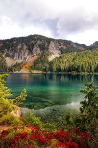 Scenic view of lake by mountains against sky