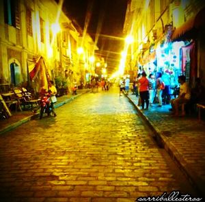 People on illuminated street at night