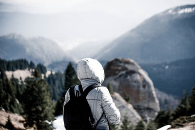 Rear view of man overlooking rocky landscape