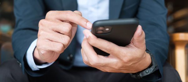Midsection of man using mobile phone