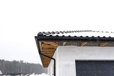 Low angle view of house against clear sky during winter