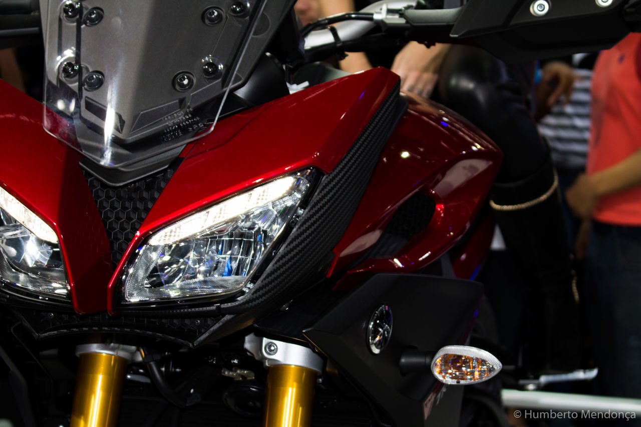 CLOSE-UP OF RED MOTORCYCLE ON ROAD