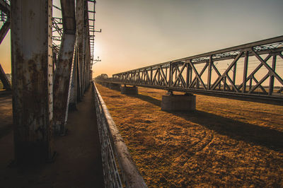 Bridge over calm river against sky