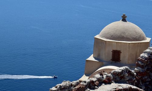 High angle view of cross by sea against blue sky