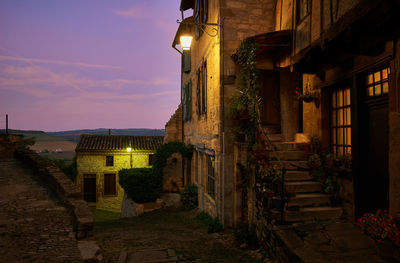 Alley amidst buildings in city at night