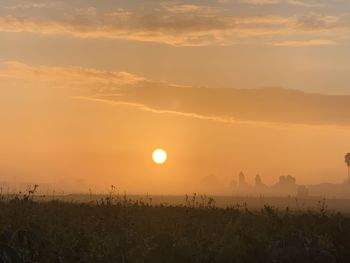 Scenic view of silhouette field against sky during sunset