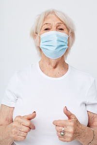 Portrait of woman with face mask against white background