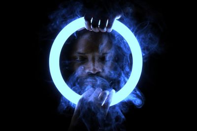 Close-up of illuminated lighting equipment against black background