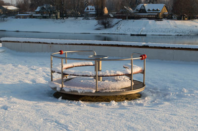 Merry-go-round at snowcapped playground during winter