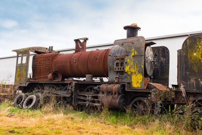 Abandoned train on land against sky