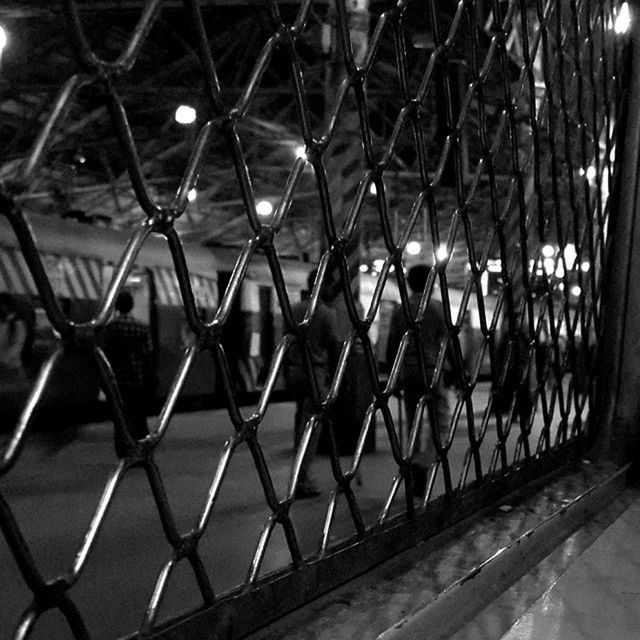 metal, fence, protection, chainlink fence, safety, railing, security, pattern, metallic, metal grate, no people, gate, illuminated, outdoors, built structure, sunlight, in a row, empty, day