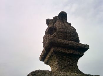 Statue of cross against sky