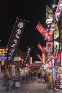 Illuminated street market in city at night