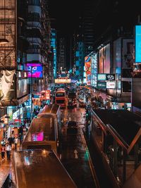 Illuminated street amidst buildings in city at night