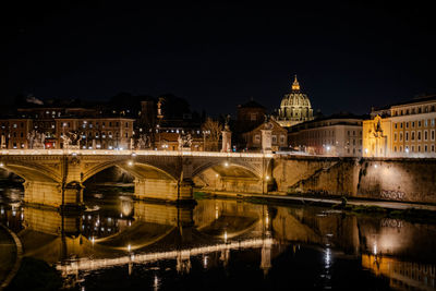 Illuminated bridge over river at night