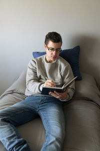 Portrait of young man sitting on sofa at home