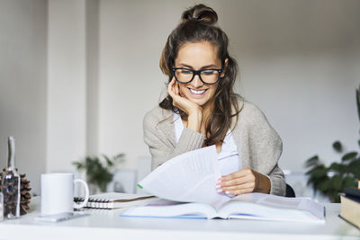 Happy female student learning at home