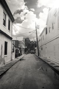 Empty road amidst buildings against sky