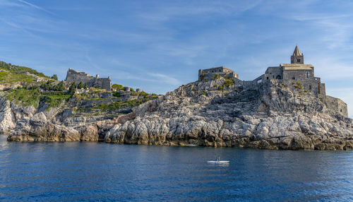 Buildings by sea against sky