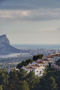 High angle view of townscape by sea against sky