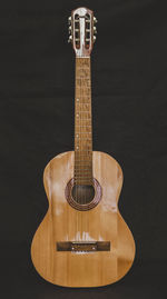 Close-up of guitar on table against black background