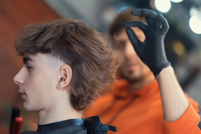 Teenager and barber showing style