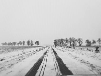 Snow covered field against clear sky