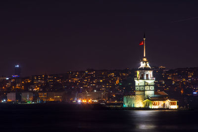 Illuminated buildings against clear sky at night