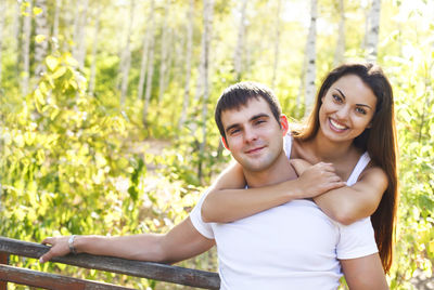 Portrait of smiling young couple against plants