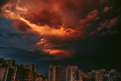 Low angle view of buildings against dramatic sky