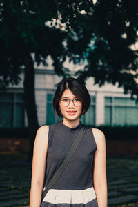 Portrait of asian young short hair beautiful woman wearing glasses and grey dress looking camera