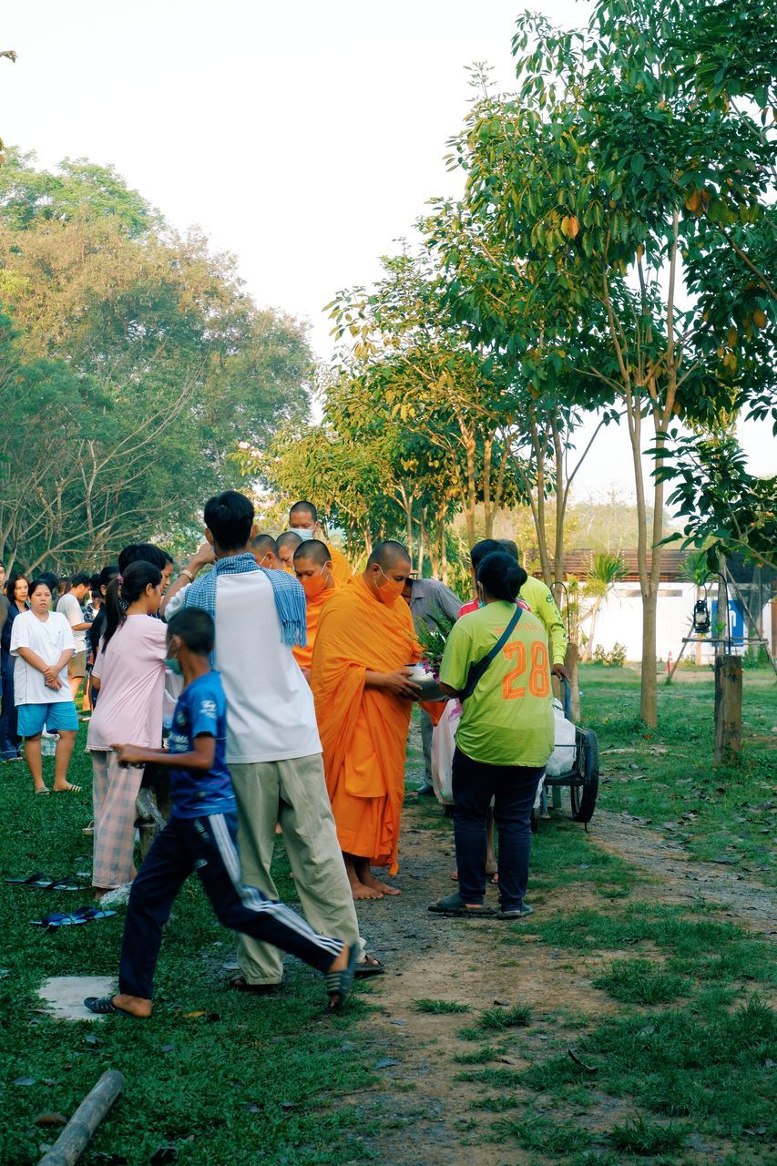 REAR VIEW OF COUPLE WALKING ON FIELD