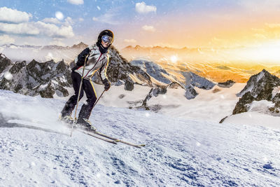 Woman standing on snow covered landscape against sky