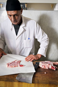 Butcher wrapping fresh meat for sale at shop