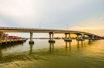 Bridge over river against sky during sunset