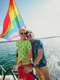 Gay couple have a vacations on a sailing yacht with lgbt rainbow flag