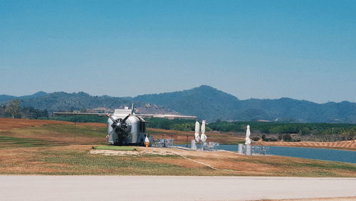 Built structure on field against clear blue sky