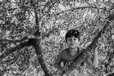 Boy with eyes closed standing on tree