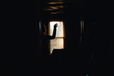 Woman gesturing in dark room