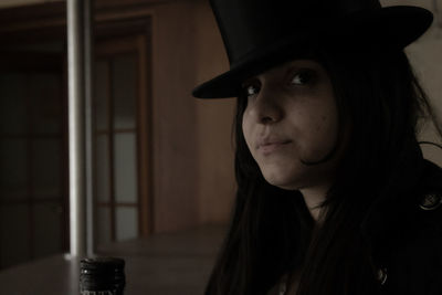 Close-up portrait of young woman looking away at home