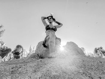 Low angle view of woman standing on field against sky