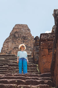 Low angle view of woman standing outside temple on steps