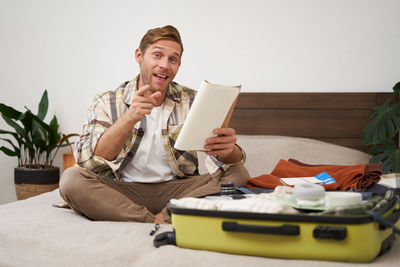 Young woman using mobile phone while sitting on sofa at home