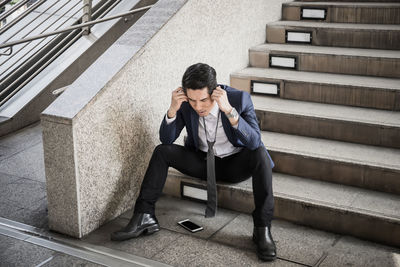 Worried businessman sitting steps