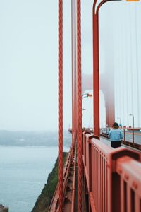 Suspension bridge over sea against clear sky