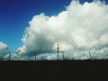 Electricity pylon on field against sky