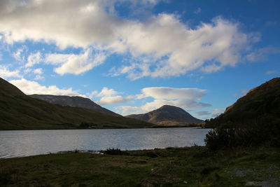 Scenic view of lake by mountains against sky