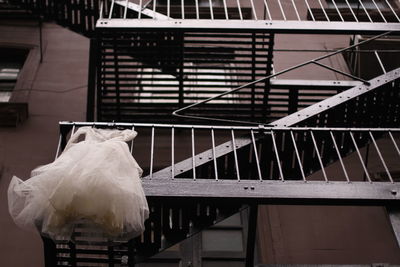 White dress hanging from fire escape of building