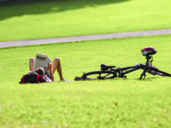 Man photographing bicycle on field